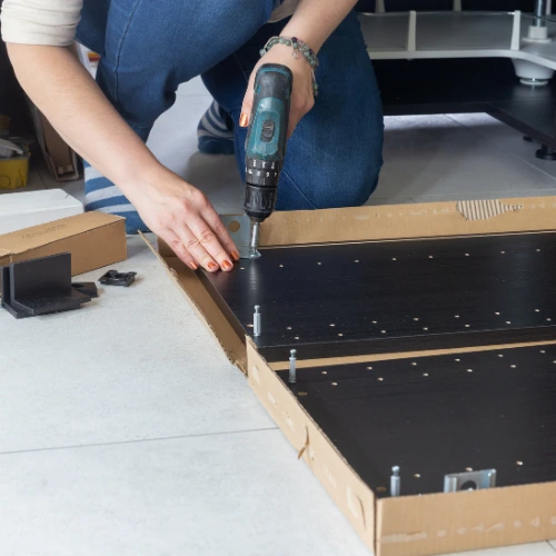 Handyman assembling furniture inside a residential home